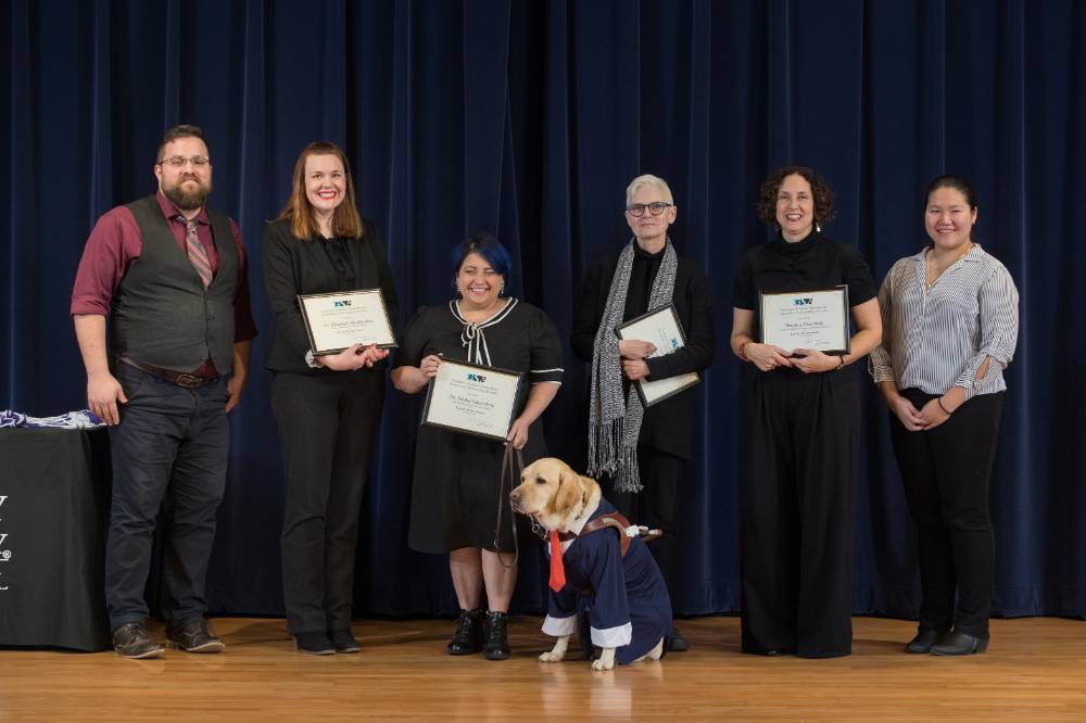 Group photo with 4 award winning professors, a professor's service dog, the GSA President and GSA Comminucations Officer